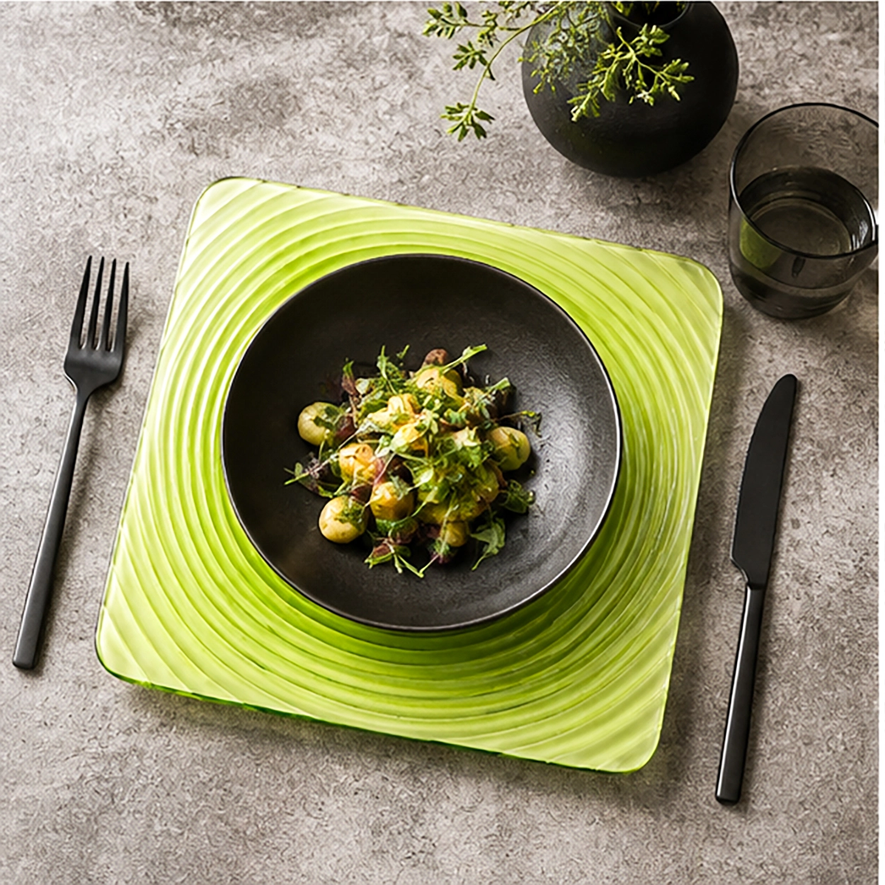 the green square swirl charger plate in a fine dining setting